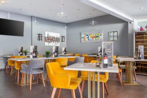 a dining room with tables and yellow chairs at Jardines del Sol in Playa Blanca
