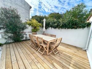 a wooden table and chairs on a wooden deck at L'évasion - Terrasse privée in La Rochelle