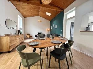 a dining room with a wooden table and chairs at L'évasion - Terrasse privée in La Rochelle