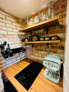 una cucina con muro di mattoni e piano cottura di Cute and Cosy Little Cottage a Heathfield
