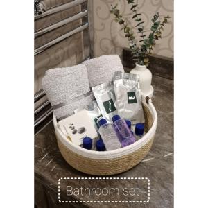 a basket of bathroom set on a table with a vase at Maslak inn in Istanbul