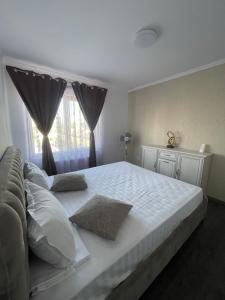 a bedroom with a large white bed with a window at Sara’S Apartament in Suceava