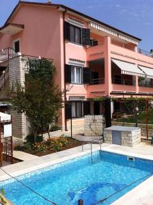 a building with a swimming pool in front of a building at Apartment Pula 8 in Veli Vrh