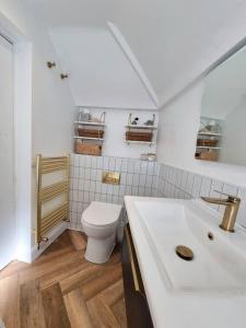 een witte badkamer met een toilet en een wastafel bij Spacious & Renovated 1-Bed Garden Flat in London in Londen