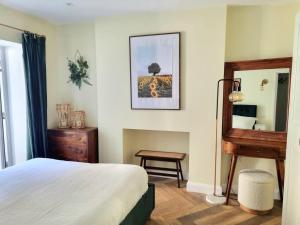 a bedroom with a bed and a mirror and a table at Spacious & Renovated 1-Bed Garden Flat in London in London