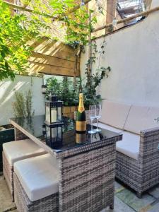 een tafel met een fles wijn op een patio bij Spacious & Renovated 1-Bed Garden Flat in London in Londen