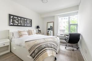 a bedroom with a bed and a desk and a chair at Spacious and Quiet Corner Apartment Downtown Toronto in Toronto