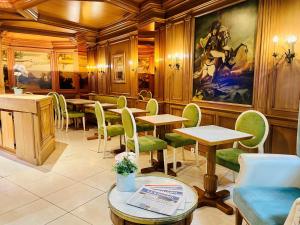 a restaurant with tables and chairs and a painting on the wall at Murat in Paris
