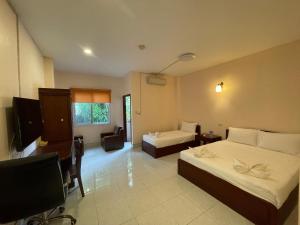 una camera d'albergo con due letti e una televisione di Hoang Kim Hotel a Vientiane