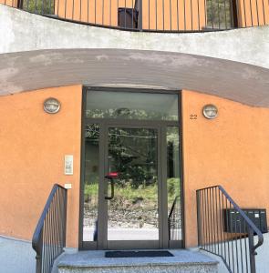 uma entrada para um edifício com uma porta de vidro em Bianchi &Bianchi casa vacanza Laveno-Mombello em Laveno