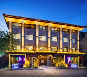 西安鸿胪花园酒店 入住赠送百威啤酒2瓶的一座大建筑前面有紫色的灯