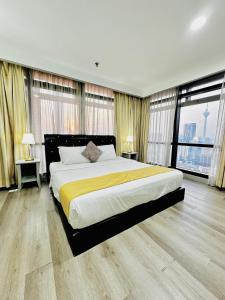 a large bedroom with a large bed with yellow sheets at Elements service suite@ Times Square in Kuala Lumpur