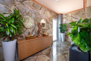 a bathroom with a stone wall with a sink and plants at Paradice Hotel Luxury Suites-Near zorbas Beach-FREE Breakfast in Stavros