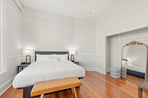 a bedroom with a large white bed and a mirror at The McKey in Valdosta