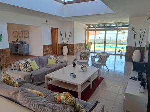 a living room with couches and a table and a pool at VILLA PARADISE in La Guirra