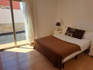 a bedroom with a bed and a large window at VILLA PARADISE in La Guirra
