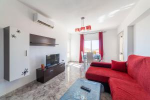 ein Wohnzimmer mit einem roten Sofa und einem TV in der Unterkunft Bahia Almeria in Aguadulce