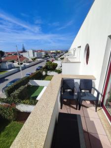 uma varanda com uma mesa e cadeiras com vista para uma rua em Milly's House em Esposende