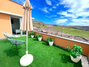 un patio con sombrilla, sillas y plantas en Villa with pool to getaway and relax, en San Bartolomé