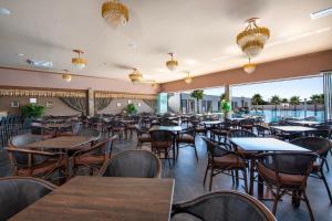 a restaurant with wooden tables and chairs and a large window at Paradice Hotel Luxury Suites-Near zorbas Beach-FREE Breakfast in Stavros