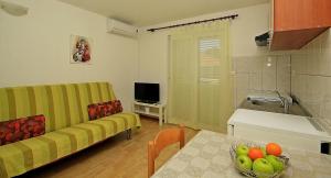 sala de estar con sofá y mesa con un bol de fruta en Apartment Makarska M&I, en Makarska