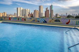 a swimming pool with a city skyline in the background at La Estación in Benidorm