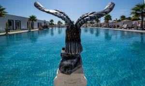 a statue in the middle of a swimming pool at Paradice Hotel Luxury Suites-Near zorbas Beach-FREE Breakfast in Stavros