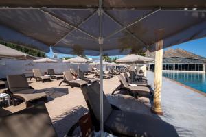 a group of lounge chairs and umbrellas next to a swimming pool at Paradice Hotel Luxury Suites-Near zorbas Beach-FREE Breakfast in Stavros