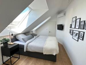 een witte slaapkamer met een bed en een raam bij Stylisches Apartment in zentraler Lage - mit Klima in Karlsruhe