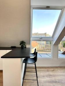 a kitchen with a black counter and a window at Stylisches Apartment in zentraler Lage - mit Klima in Karlsruhe