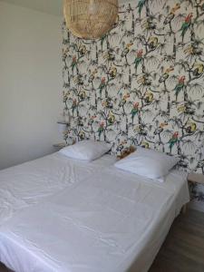 ein Bett in einem Schlafzimmer mit einer Tapete mit Vögeln darauf in der Unterkunft Gîte de La Promenade - proche du Zoo de Beauval in Valençay