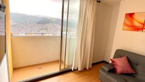 ein Wohnzimmer mit einem Sofa und einem großen Fenster in der Unterkunft Av santander apartamento perfecta ubicación in Manizales