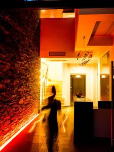 une personne traversant une pièce avec un mur en briques dans l'établissement Bebis Hotel, à Kokkino Nero