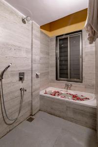 a bathroom with a bath tub and a sink at Freesia Resort by Express Inn in Nashik