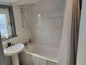 a bathroom with a tub and a sink and a shower at Westview in Buckie