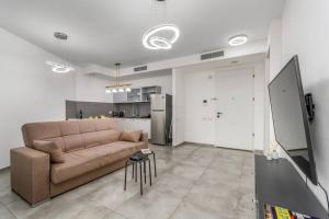 a living room with a couch and a kitchen at New Branch Gindi Tower 1BR with Parking in Tel Aviv