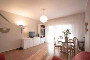 a living room with a dining table and a television at LC Apartaments Av del Mar in Castellón de la Plana