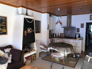 a living room with a table and a kitchen at Appartement sur piste à Praloup in Uvernet-Fours +7 photos