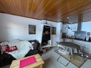 a living room with a couch and a table at Appartement sur piste à Praloup in Uvernet-Fours