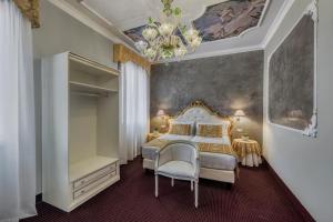 a bedroom with a bed and a chandelier at Hotel Pausania in Venice