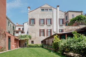an old brick building with a lawn in front of it at Hotel Pausania in Venice