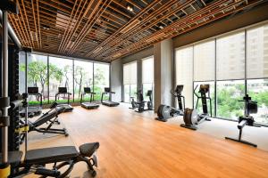 een fitnessruimte met loopbanden en crosstrainers in een kamer met ramen bij Royal State - The Ascentia Phu My Hung in Ho Chi Minh-stad