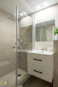 a bathroom with a shower and a sink and a mirror at Eshkol Housing Haifa-Disraeli Urban & Business boutique Apartments complex in Haifa