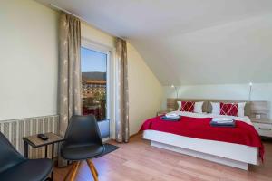 1 dormitorio con cama roja y ventana en Pension Bayerwald, en Bodenmais
