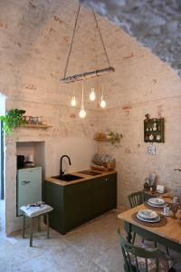 a kitchen with a sink and a table with chairs at La Casetta in Alberobello