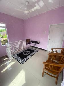 Zimmer mit lila Wänden und einer Treppe mit einem Stuhl in der Unterkunft Dan's Homestay Bangau in Temerloh