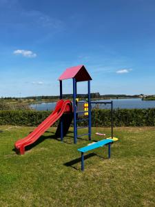 un parque infantil con tobogán y tobogán en Sterla - Masuria, en Giżycko