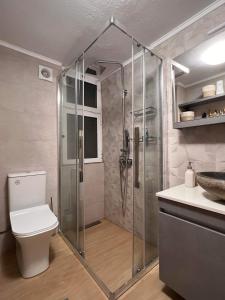 y baño con ducha, aseo y lavamanos. en Beach Retreat in town en Kórinthos