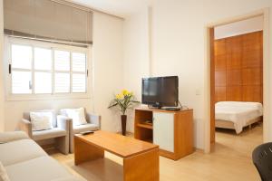 a living room with a couch and a tv in it at Apt South Beach Residence Club in Rio de Janeiro