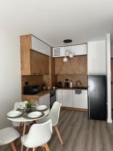 a kitchen with a table and chairs and a refrigerator at SkyTravel 26 Apartament Pileckiego Nowy Dwór Mazowiecki Airport Modlin 24H in Nowy Dwór Mazowiecki